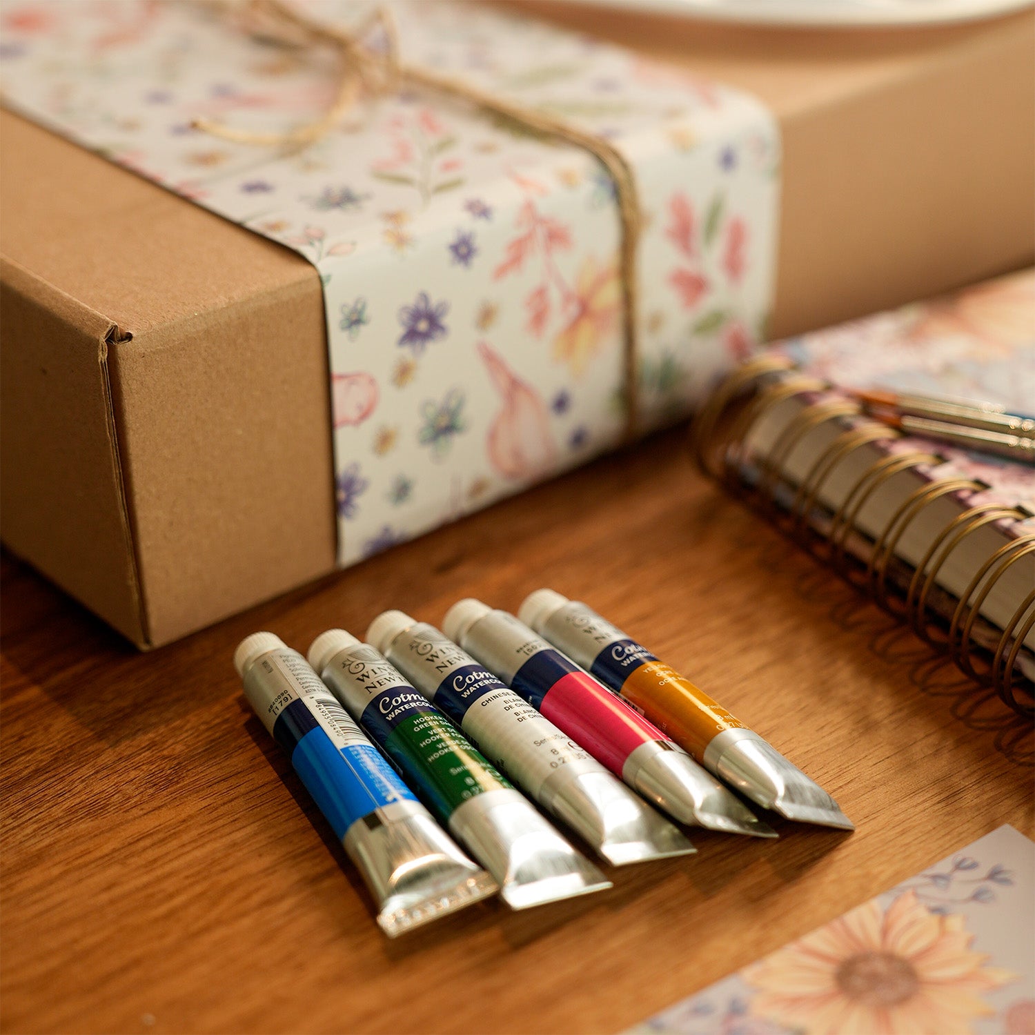 Cinco tubos de acuarelas sobre una mesa.